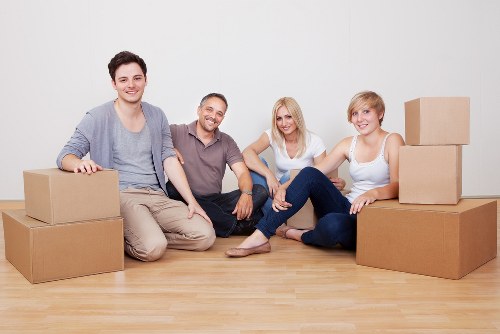 Movers handling boxes and furniture near Canary Wharf residential buildings
